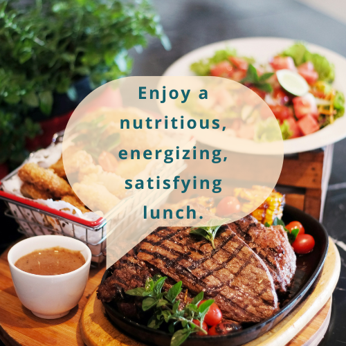 A delicious and nutritious lunch featuring a grilled steak with fresh cherry tomatoes and herbs, accompanied by crispy sides, dipping sauce, and a refreshing salad in the background.